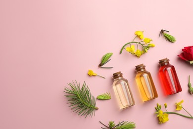 Photo of Aromatherapy. Different essential oils, fir twigs and flowers on pink background, flat lay. Space for text