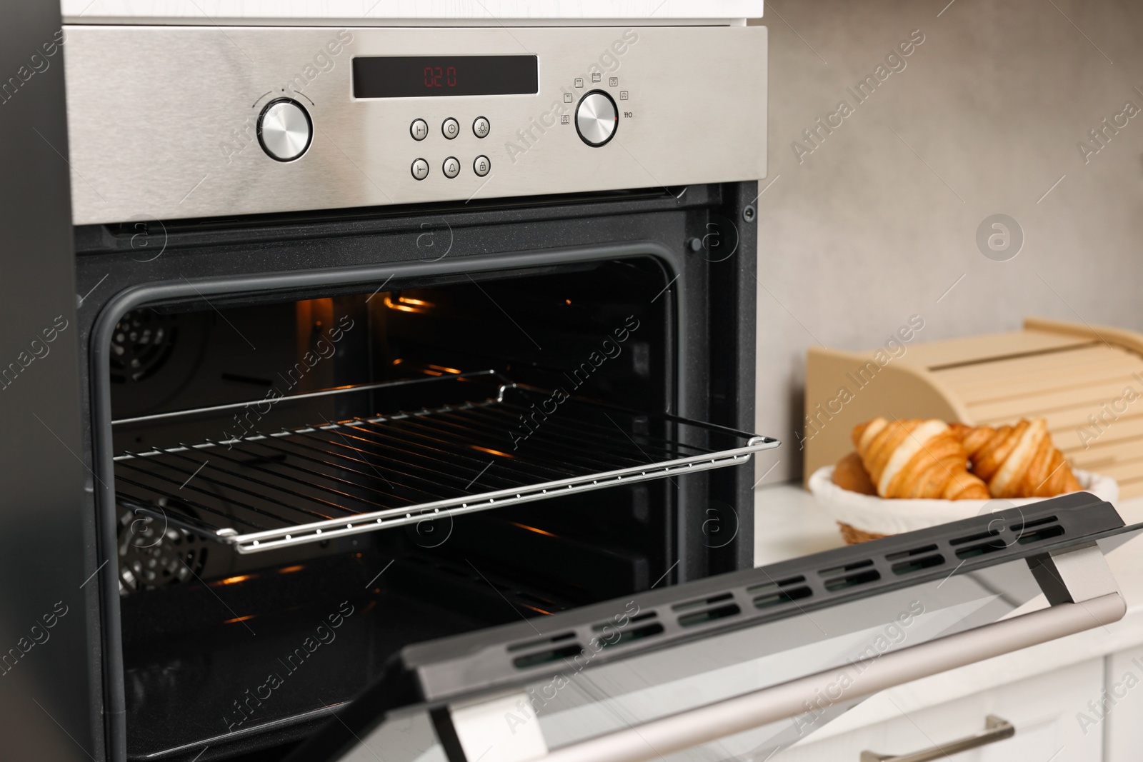 Photo of Open electric oven in kitchen. Cooking appliance