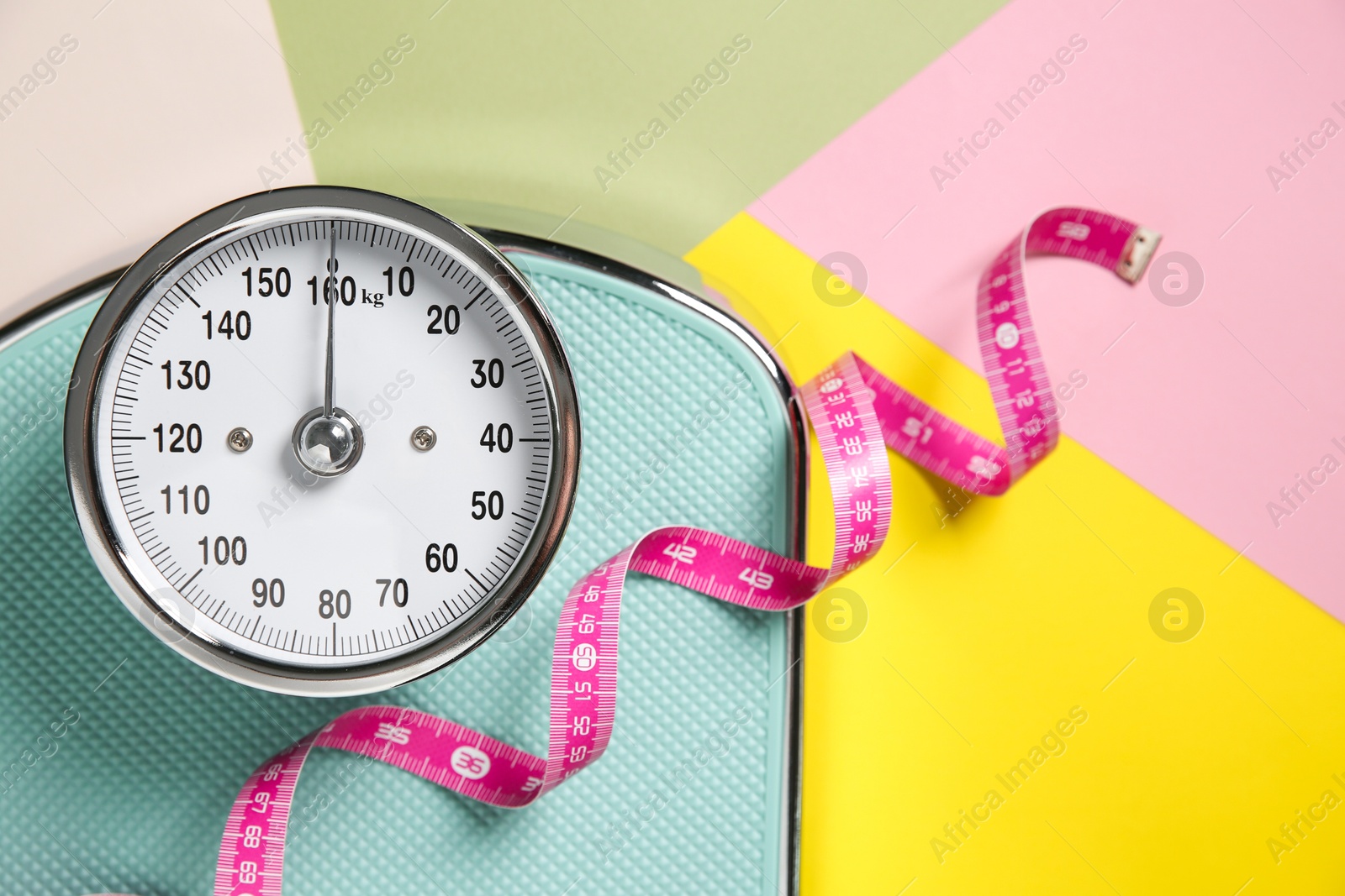 Photo of Scale and measuring tape on color background, flat lay