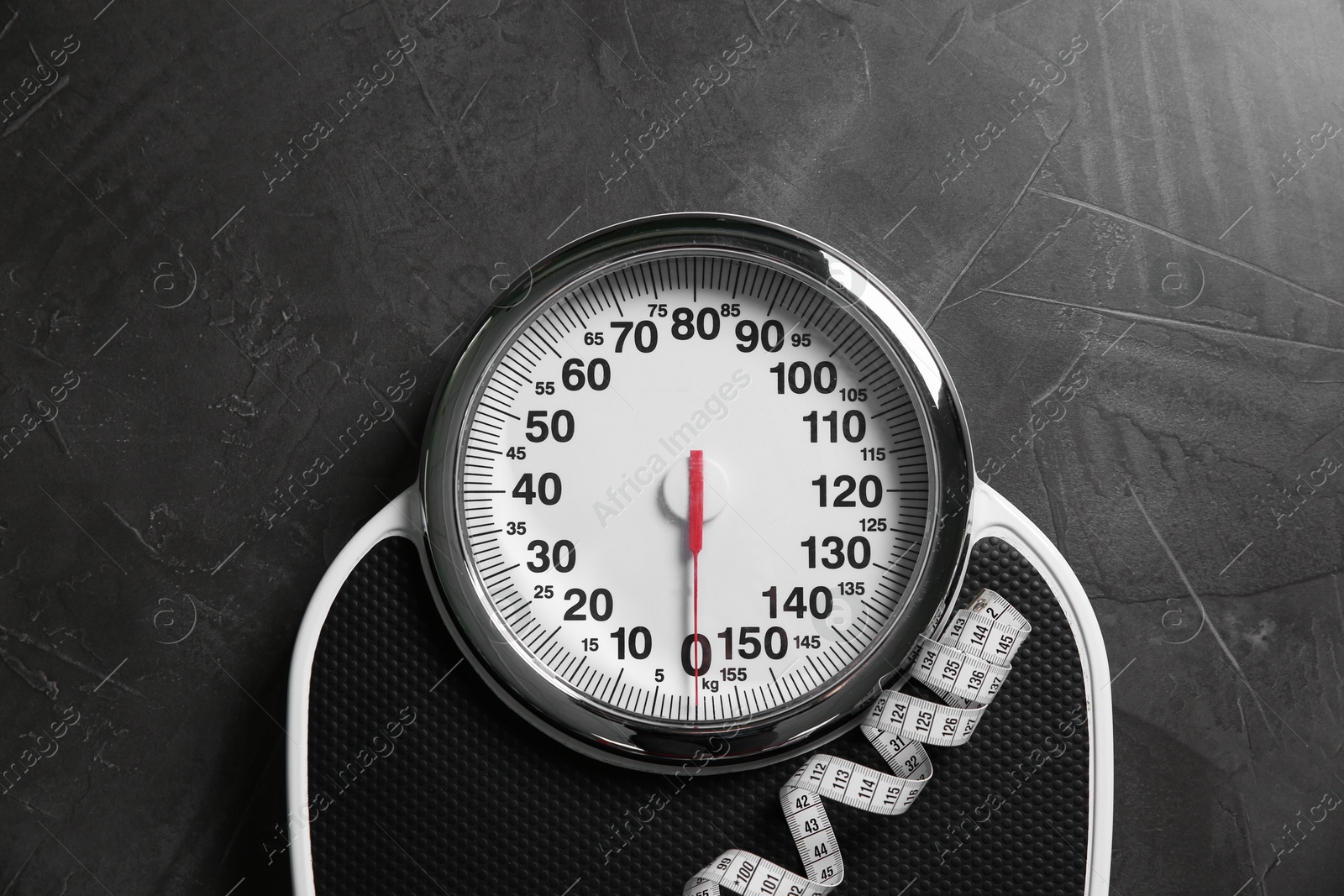 Photo of Scale and measuring tape on grey textured background, top view