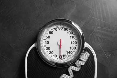 Photo of Scale and measuring tape on grey textured background, top view