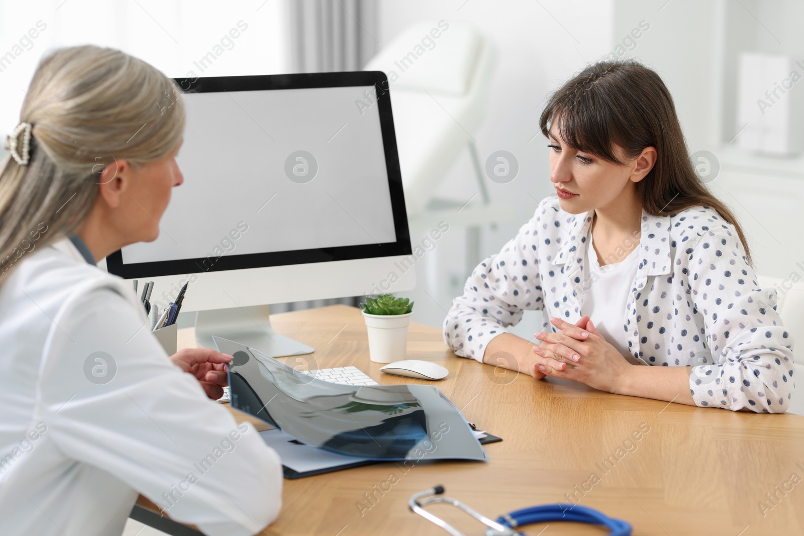 Photo of Lung disease. Doctor showing chest x-ray to her patient in clinic