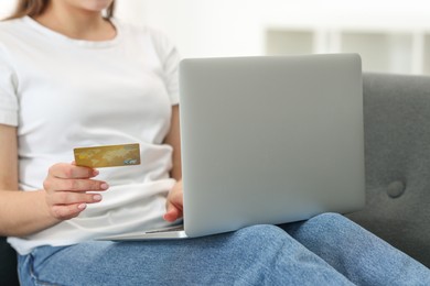 Photo of Online banking. Woman with credit card and laptop paying purchase at home, closeup