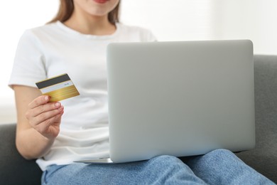 Photo of Online banking. Woman with credit card and laptop paying purchase at home, closeup