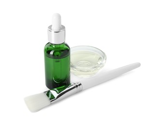 Photo of Bottle of chemical peel, bowl with liquid and brush isolated on white. Peeling procedure