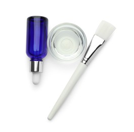 Photo of Bottle of chemical peel, bowl with liquid and brush isolated on white, top view. Peeling procedure