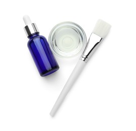 Photo of Bottle of chemical peel, bowl with liquid and brush isolated on white, top view. Peeling procedure