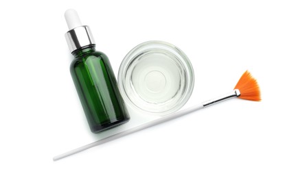 Photo of Bottle of chemical peel, bowl with liquid and brush isolated on white, top view. Peeling procedure