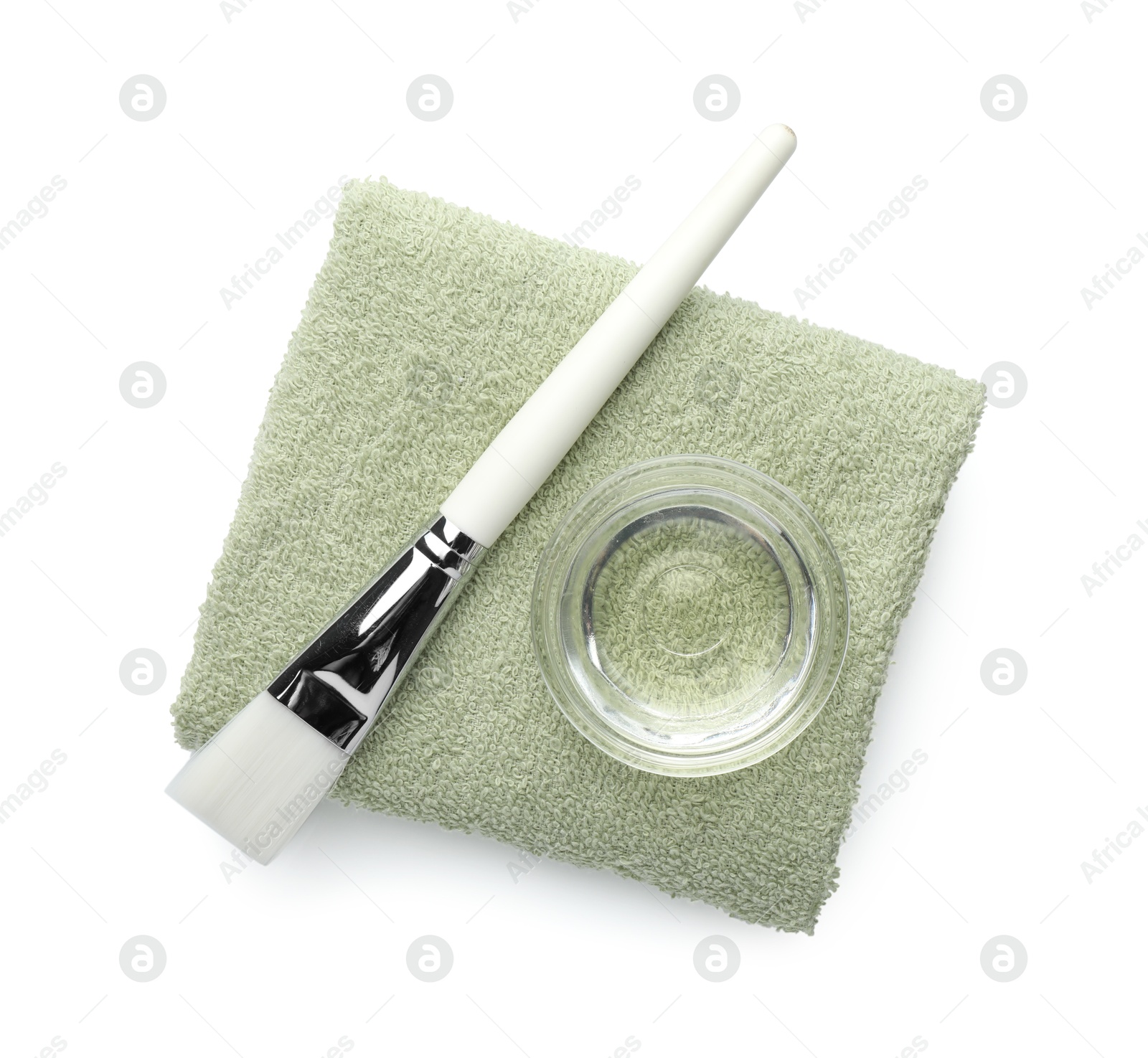 Photo of Bowl of chemical peel, towel and brush isolated on white, top view. Peeling procedure