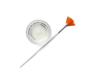 Photo of Bowl of chemical peel and brush isolated on white, top view. Peeling procedure