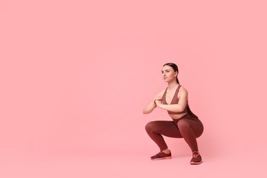 Photo of Young woman doing aerobic exercise on pink background. Space for text