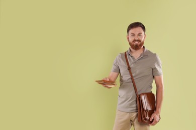 Postman with brown bag delivering letters on light green background. Space for text