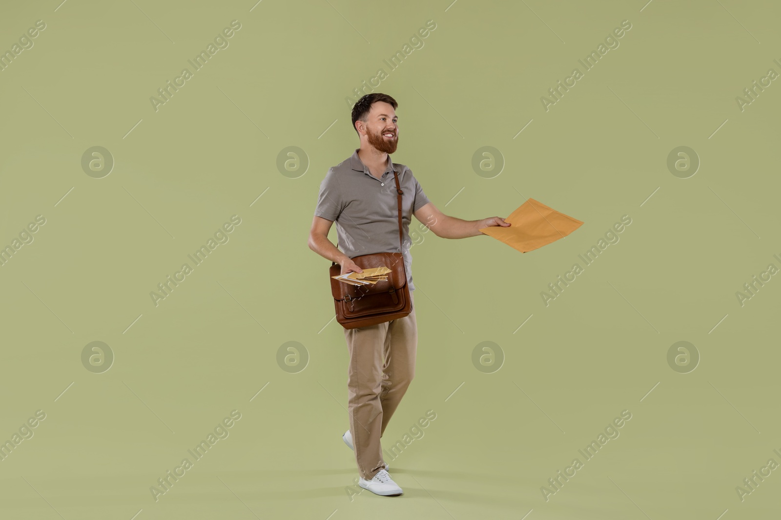 Photo of Postman with brown bag delivering letters on light green background