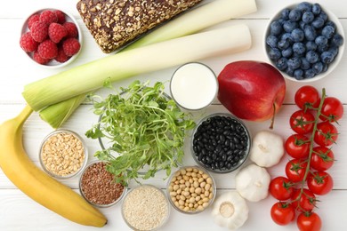 Different fresh products on white wooden table, flat lay. Source of prebiotics