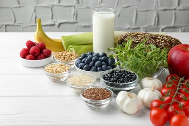 Photo of Different fresh products on white wooden table. Source of prebiotics