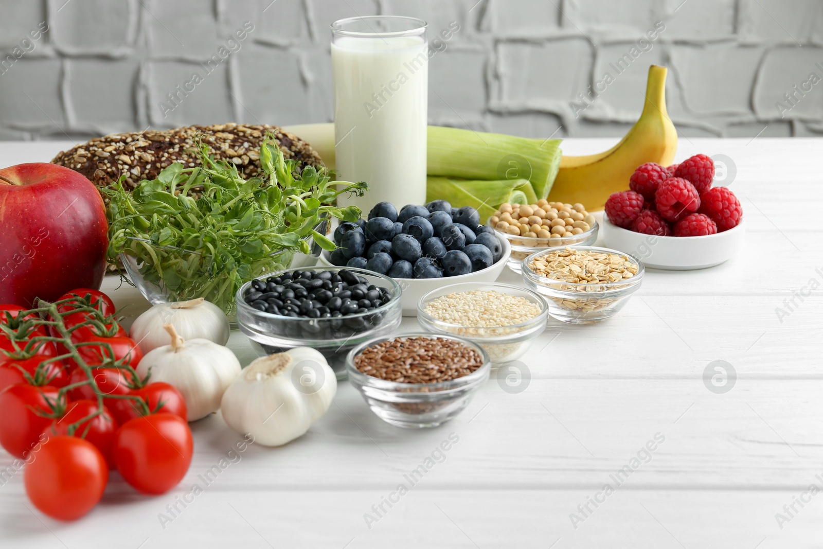 Photo of Different fresh products on white wooden table, space for text. Source of prebiotics