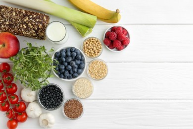 Photo of Different fresh products on white wooden table, flat lay and space for text. Source of prebiotics