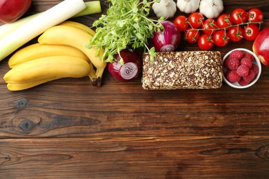 Photo of Different fresh products and space for text on wooden table, flat lay. Source of prebiotics