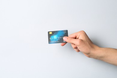 Photo of Man holding credit card on light grey background, closeup