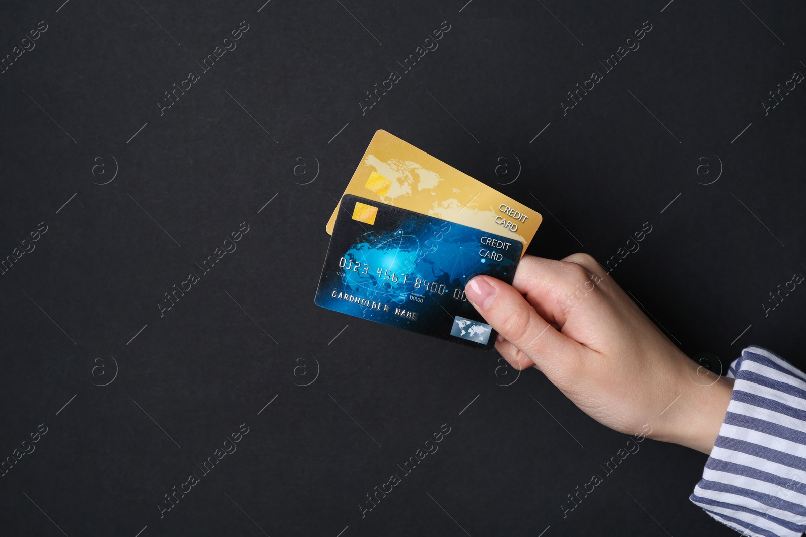 Photo of Woman holding credit cards on black background, closeup