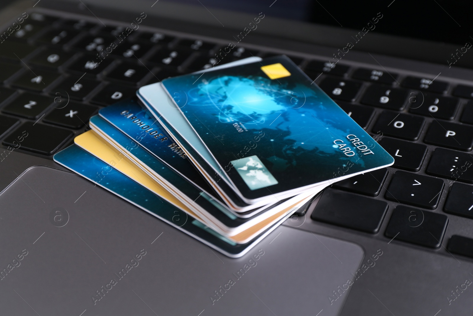 Photo of Many plastic credit cards on laptop, closeup