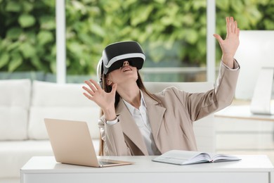 Photo of Woman using virtual reality headset in office