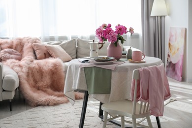 Beautiful table setting with pink peonies in living room