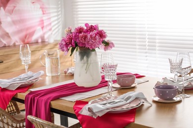 Photo of Beautiful table setting with pink peonies in dining room