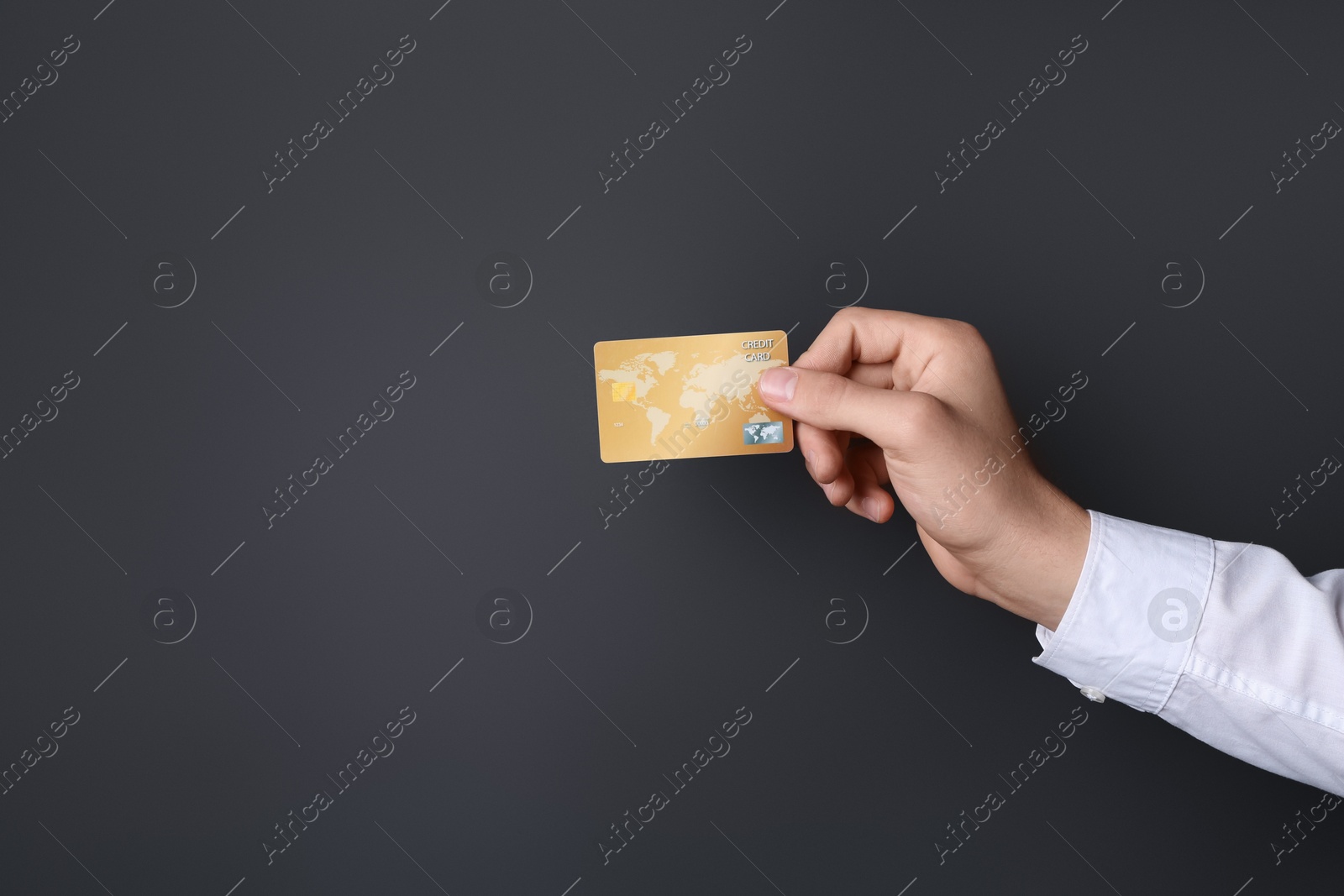 Photo of Man holding credit card on black background, closeup