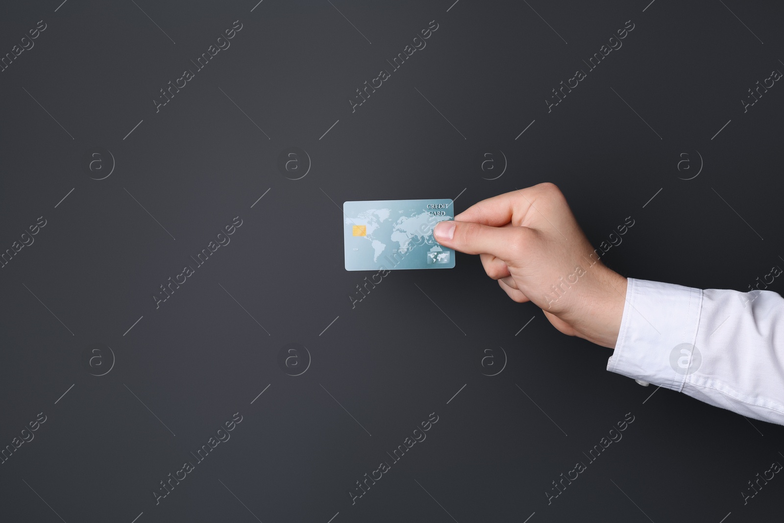 Photo of Man holding credit card on black background, closeup