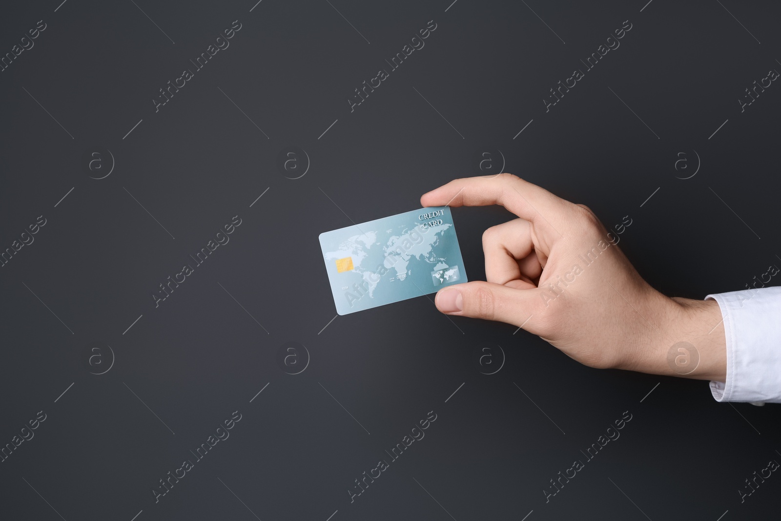 Photo of Man holding credit card on black background, closeup