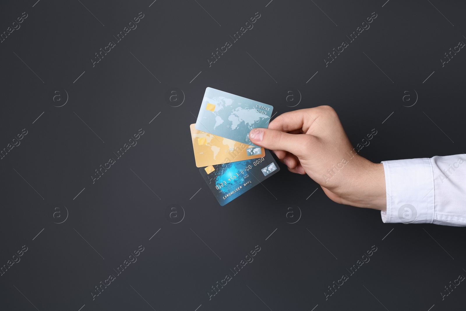 Photo of Man holding credit cards on black background, closeup