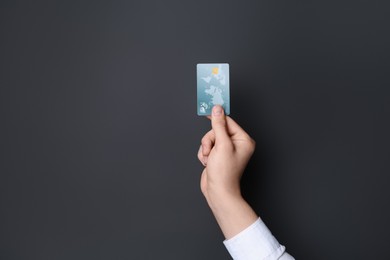 Man holding credit card on black background, closeup