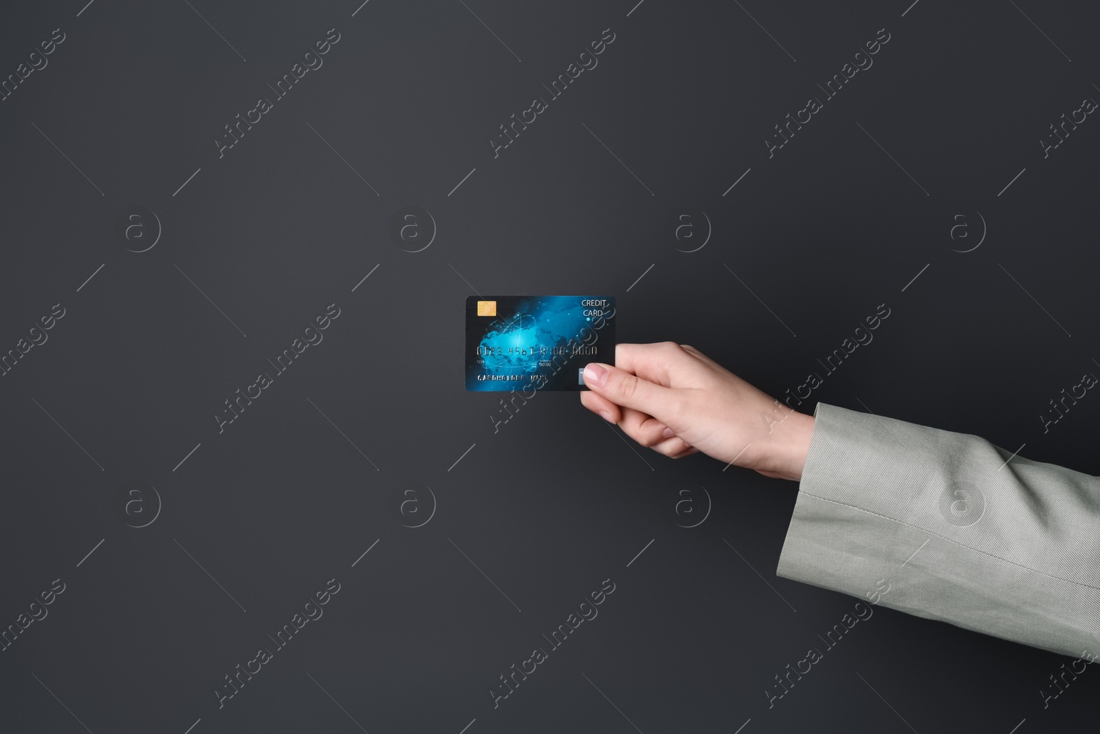 Photo of Woman holding credit card on black background, closeup