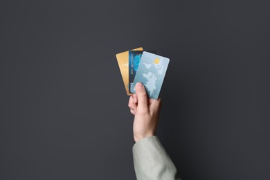 Photo of Woman holding credit cards on black background, closeup