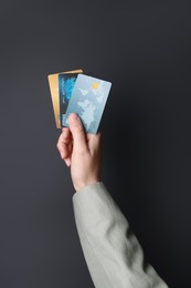 Photo of Woman holding credit cards on black background, closeup