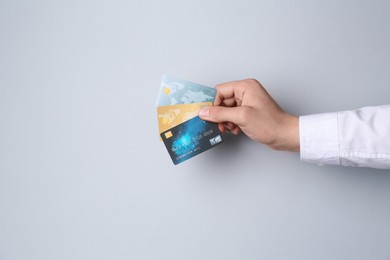 Photo of Man holding credit cards on light grey background, closeup