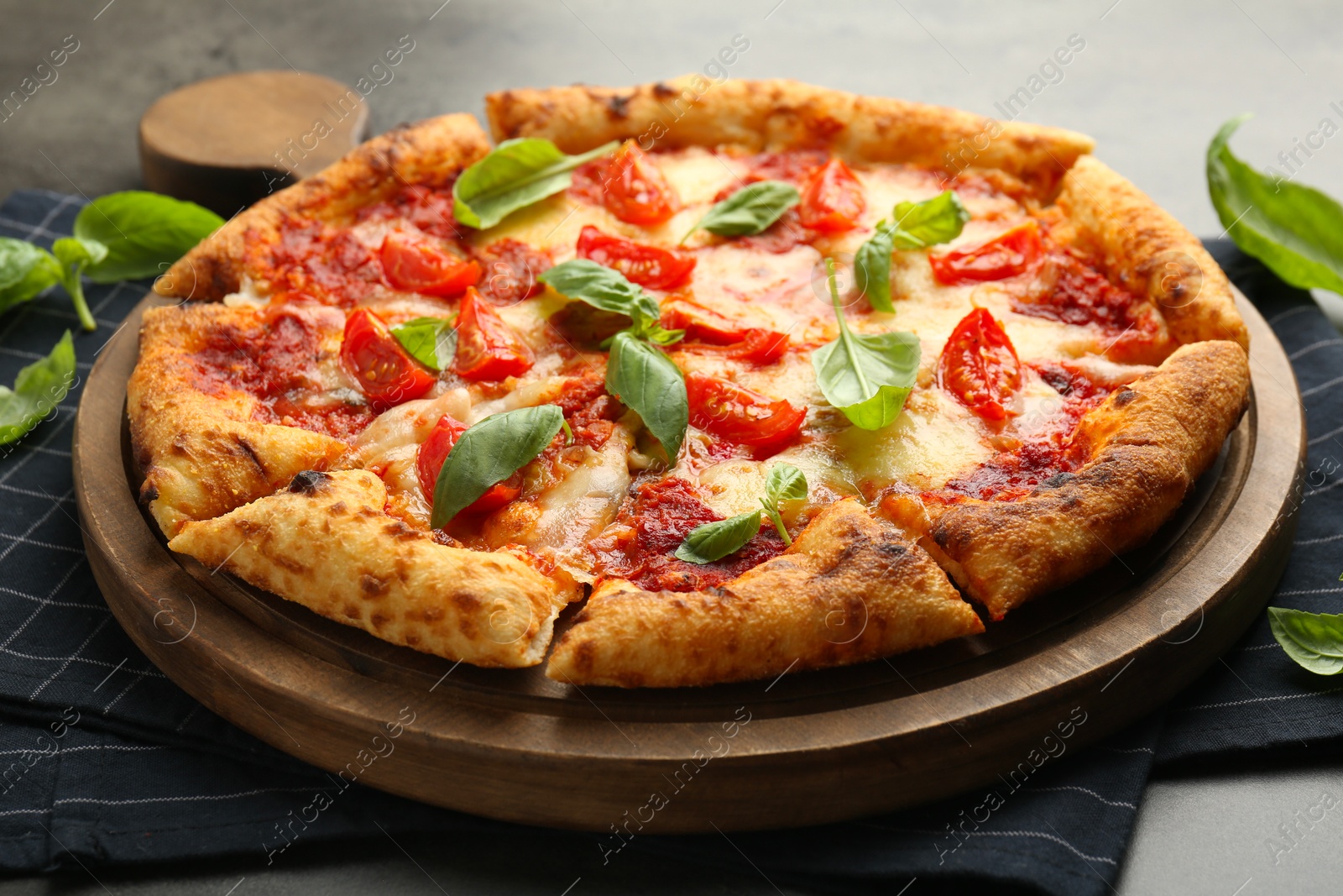 Photo of Delicious Margherita pizza and basil on table