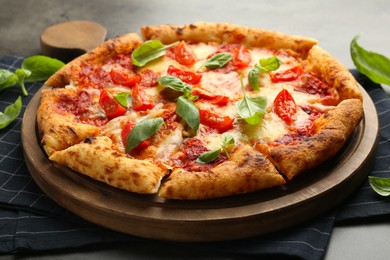 Photo of Delicious Margherita pizza and basil on table