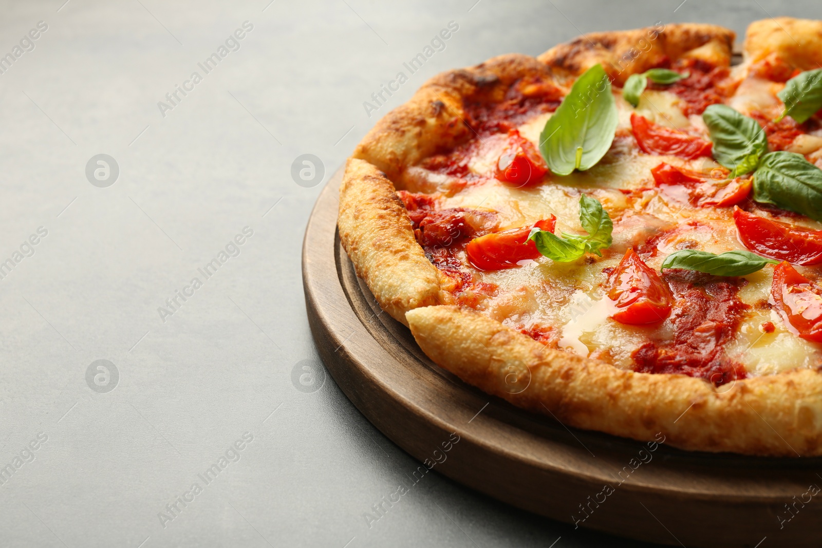 Photo of Delicious Margherita pizza on grey table, closeup. Space for text