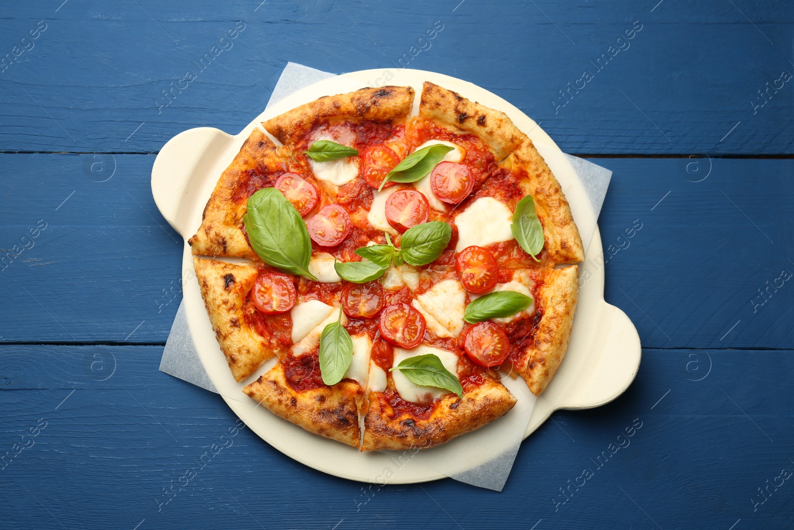 Photo of Delicious Margherita pizza on blue wooden table, top view