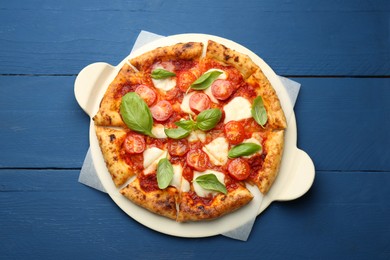 Delicious Margherita pizza on blue wooden table, top view