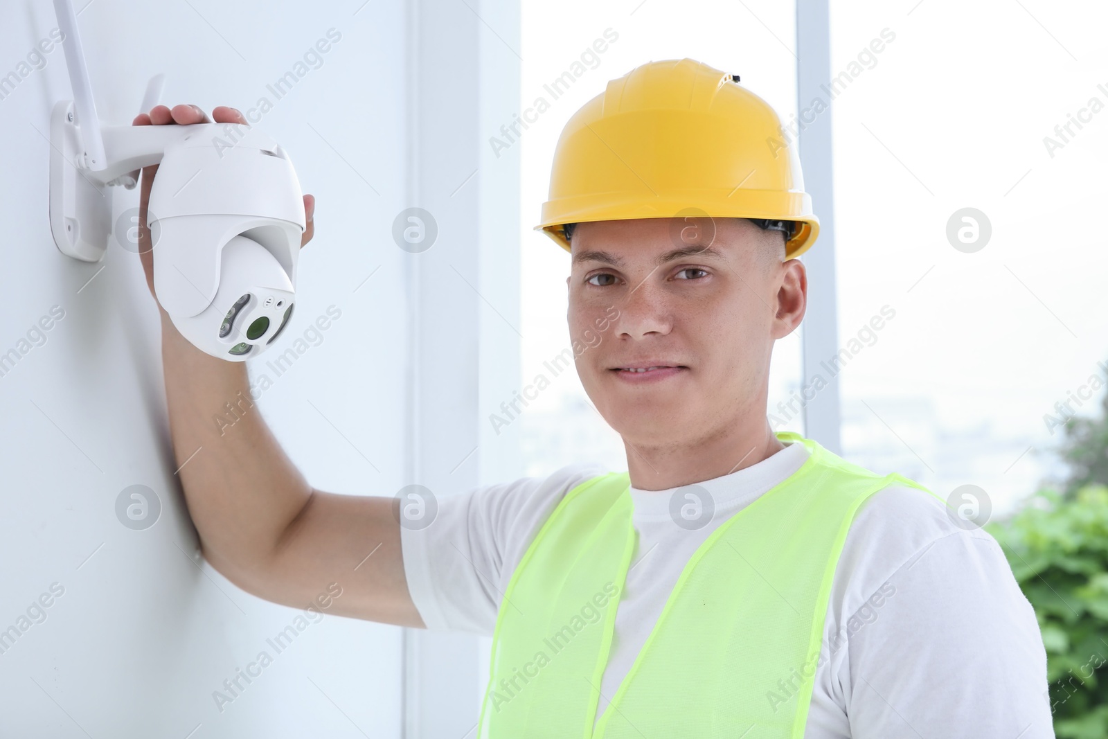 Photo of Portrait of technician in helmet near CCTV camera