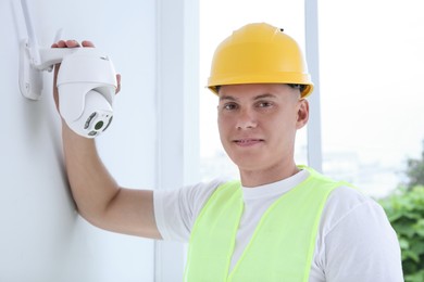 Portrait of technician in helmet near CCTV camera