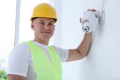 Portrait of technician in helmet near CCTV camera