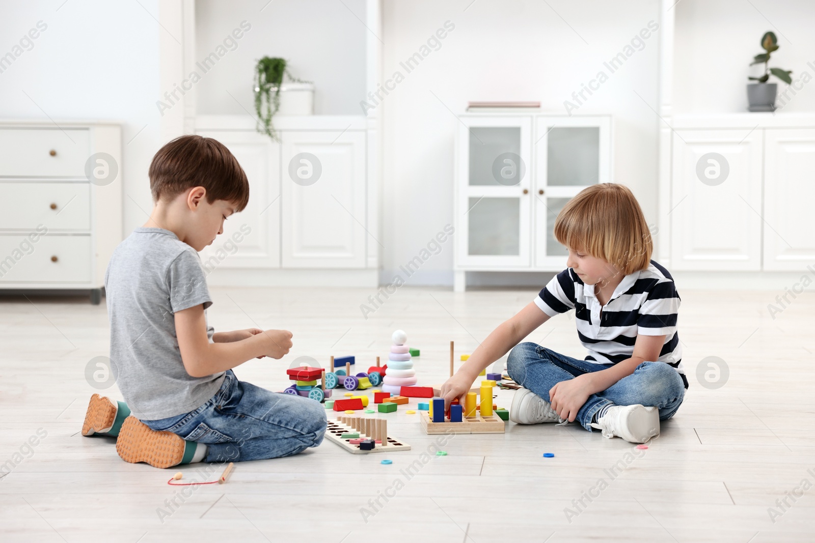 Photo of Cute little children playing together on floor indoors