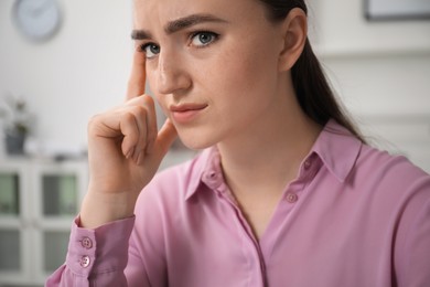 Photo of Embarrassed young woman in office, closeup view