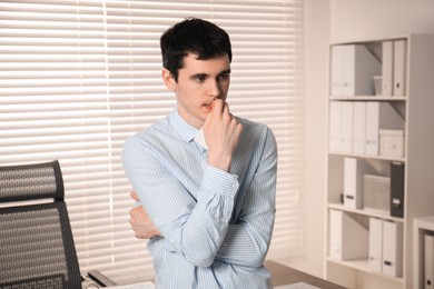 Photo of Portrait of embarrassed young man in office