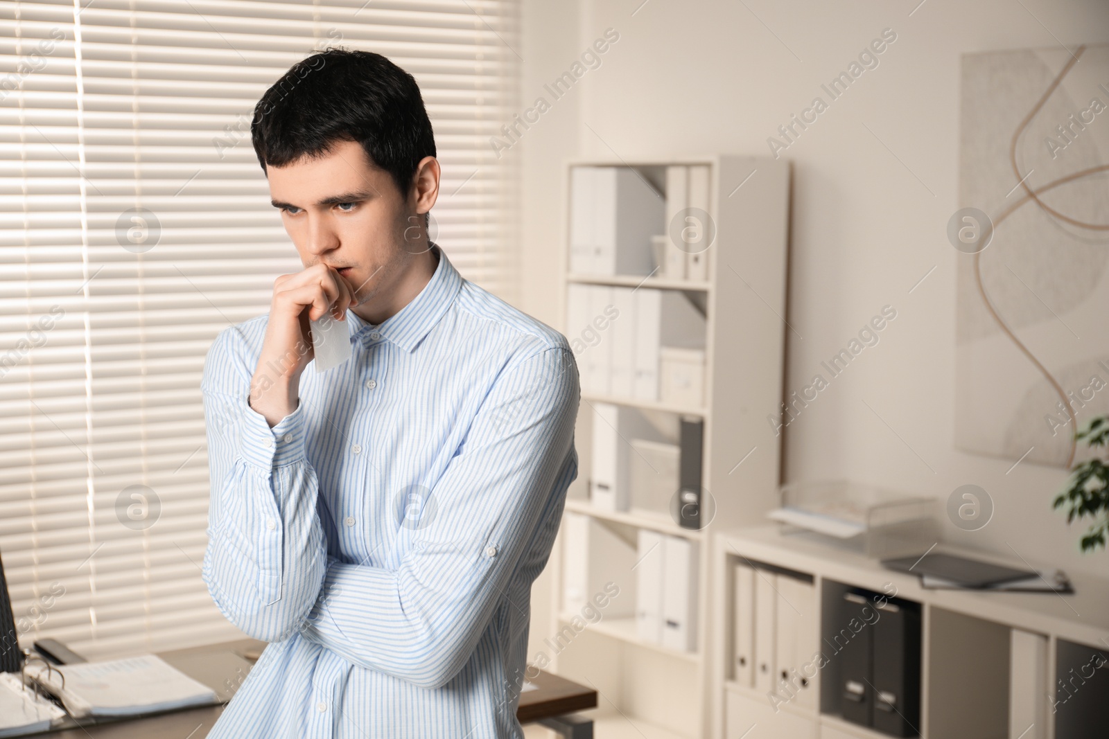 Photo of Portrait of embarrassed young man in office