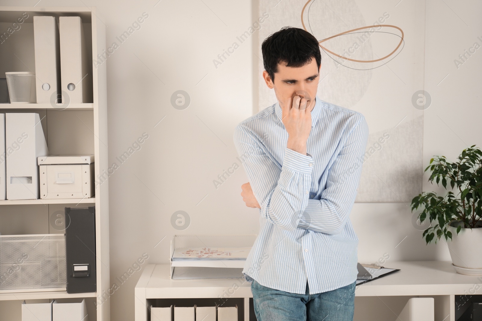 Photo of Portrait of embarrassed young man in office